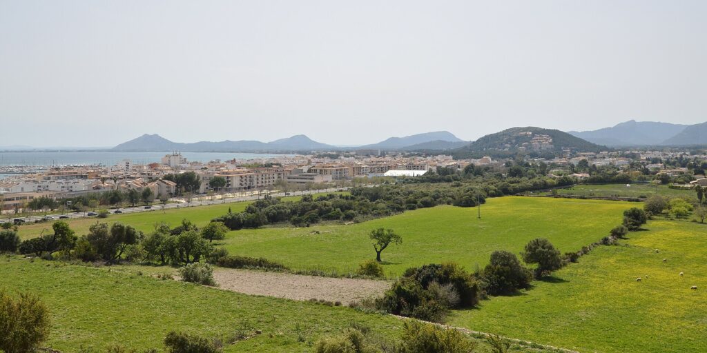 Strand en baai van Port de Pollença op Mallorca bij zonnig weer